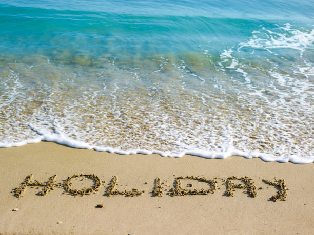istock Holidays written in the sand on the beach 1322915035