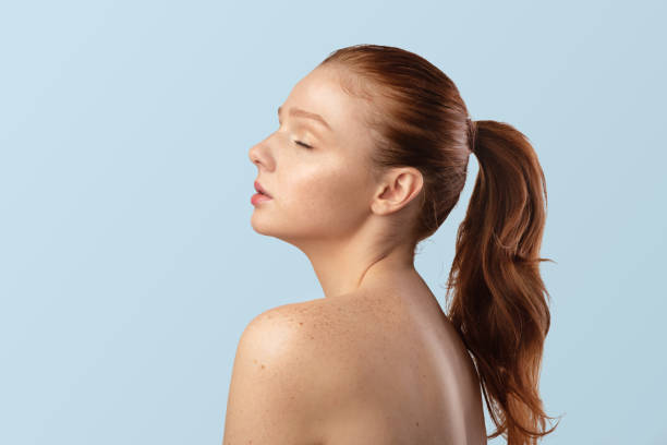 istock Sensual Red-Haired Young Lady Posing Shirtless, On Blue Background, Side-View 1322915466