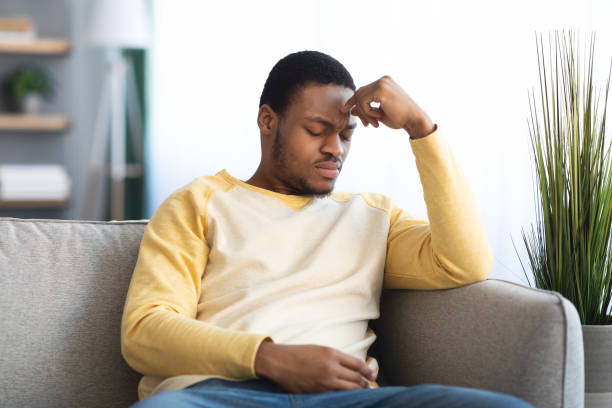 istock Depressed black guy sitting on couch alone at home 1322916848