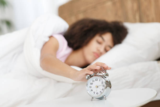 istock Lady turns off alarm clock, waking up in morning from call 1322918081