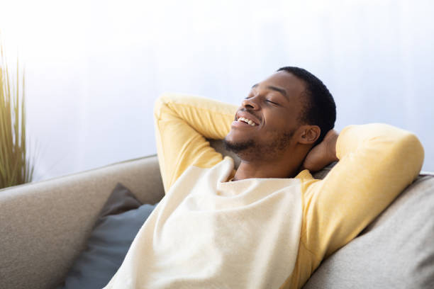 istock Closeup of black guy relaxing on couch at home 1322918806