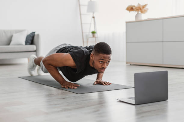 istock African Guy Doing Push-Ups Exercise Near Laptop On Floor Indoor 1322920932