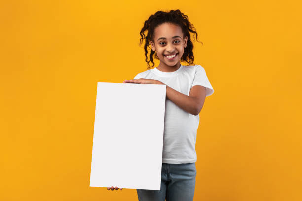 istock Black girl holding blank white advertising billboard at studio 1322920999