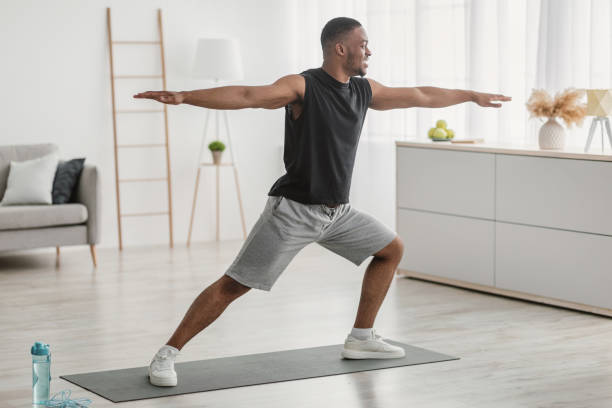 istock African American Man Doing Yoga Standing In Warrior Pose Indoor 1322921093