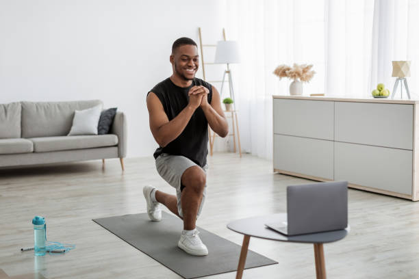 istock Black Man Doing Forward Lunge Exercising Near Laptop At Home 1322921149