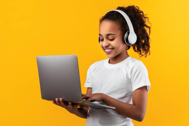 istock Black girl in headset standing with laptop at studio 1322921419
