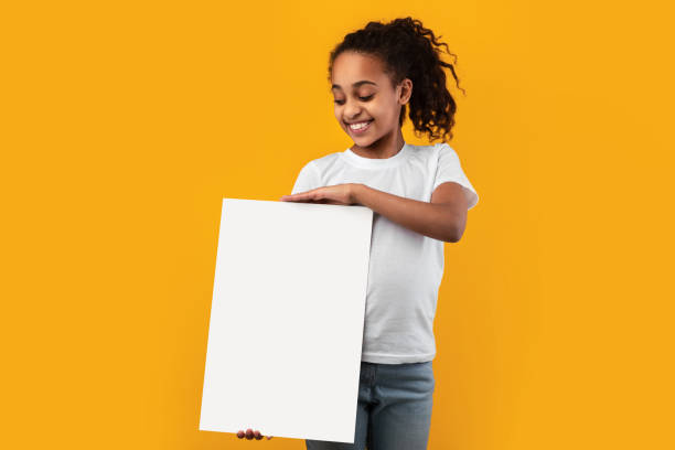 istock Black girl holding blank white advertising billboard at studio 1322922244