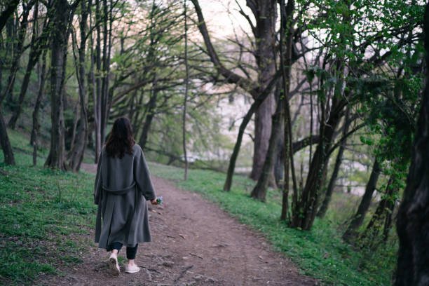 istock Young woman walks through dense forest 1322924495