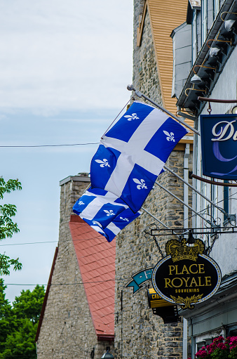 Quebec flags on a building wall in Old Quebec during day of springtime