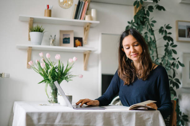 istock Young woman works from home at kitchen table 1322924790