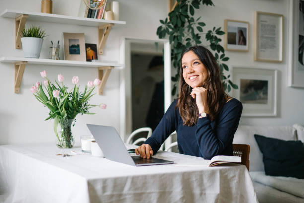 istock Young woman works from home at kitchen table 1322924809