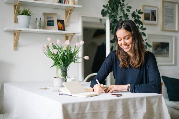 istock Young woman works from home at kitchen table 1322924848