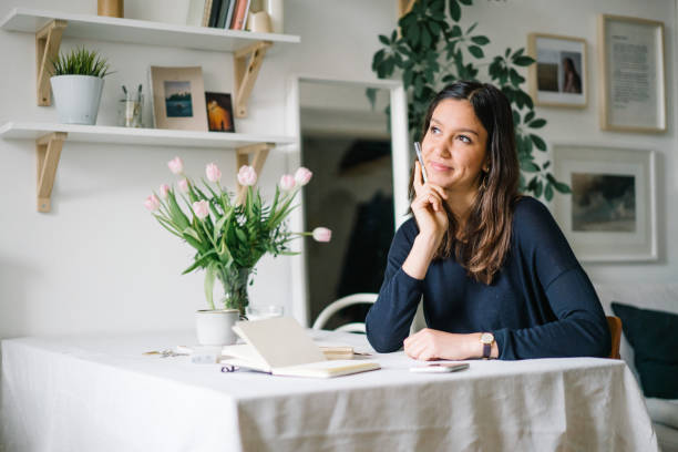 Young woman works from home at kitchen table