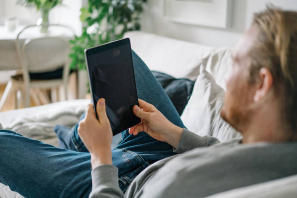istock Young man works online from living room 1322925992