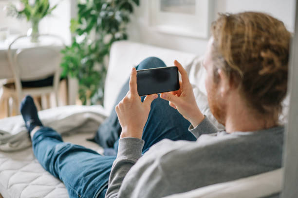 istock Young man relaxes in living room during quarantine 1322926549