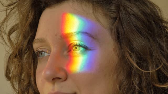 Brunette with short hair opens eyes and rainbow appears