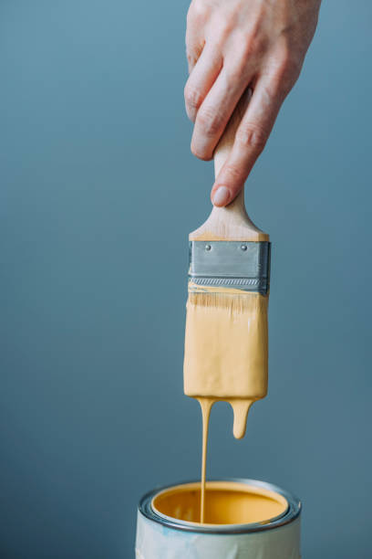 mujer prueba pintura amarilla con pincel - folding hands fotografías e imágenes de stock