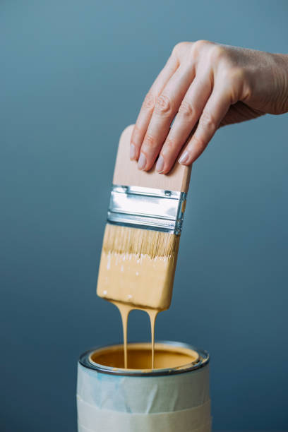 istock Woman Testing Yellow Paint With Paintbrush 1322927701