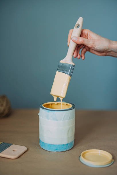 istock Woman Testing Yellow Paint With Paintbrush 1322927711