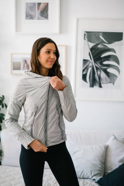 Young woman gets dressed in activewear at home