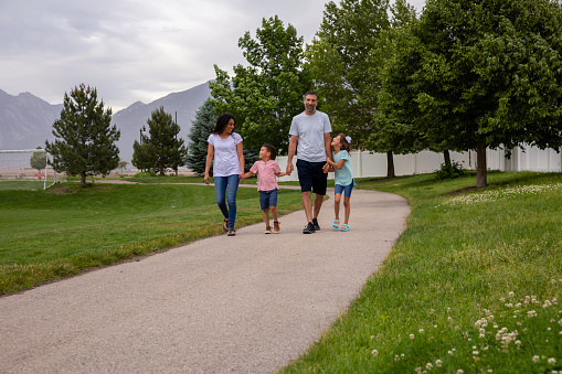 A mother and father, walk with their two children in a public park in Draper, Utah.