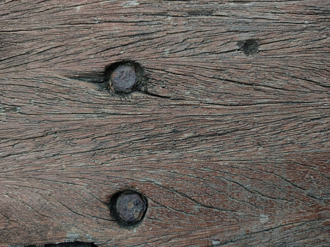 The old wooden surface has two screws to fix it, judging by its age, it has been used for a long time and there are visible signs of decay on the wooden floor. and rust clinging to the screw