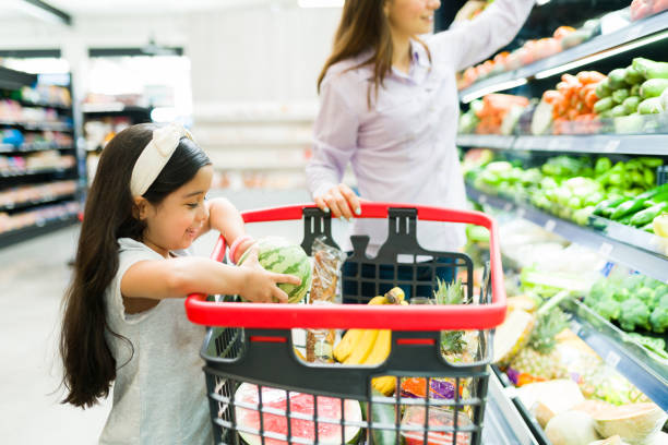 istock Cute kid helping mom shopping groceries 1322935418