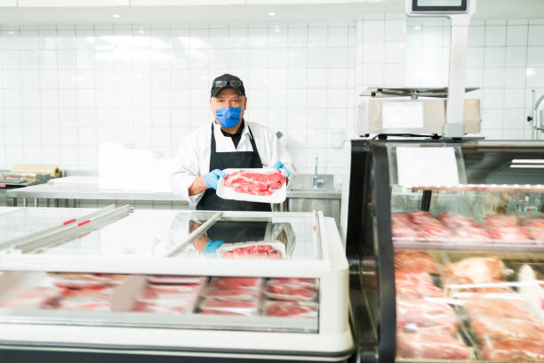 istock Butcher offering and selling quality steak 1322935610