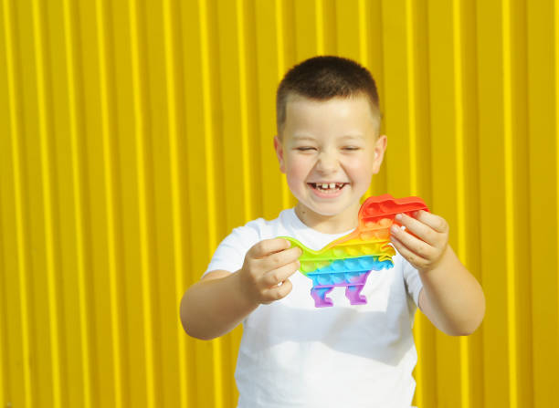 istock Boy plays with pop it game on yellow color background 1322937768
