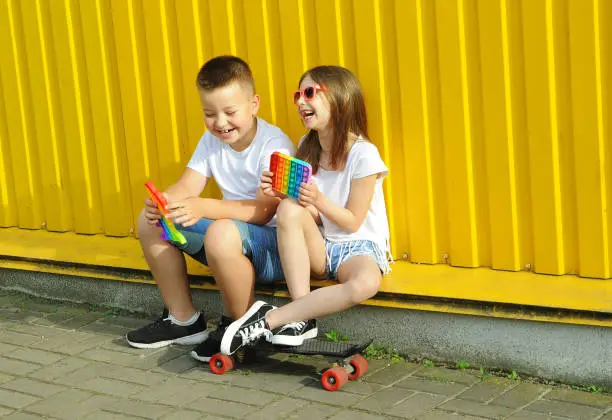 Photo of teenagers holds pop it game in hand outdoors