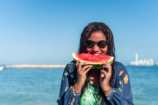 istock woman eating watermelon at the beach 1322938746