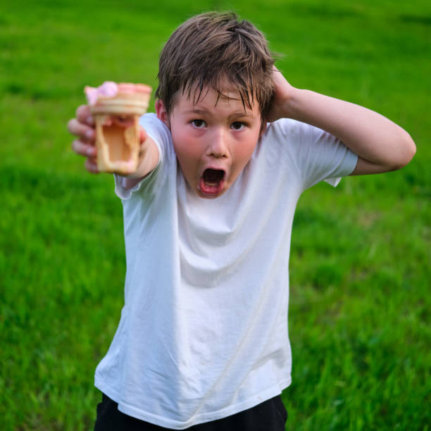 Amazed boy with empty fake ice cream, food problems Amazed boy with empty fake ice cream, food problems stealing ice cream stock pictures, royalty-free photos & images