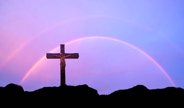 istock Jesus Christ statue over purple sky with double rainbow 1322942401
