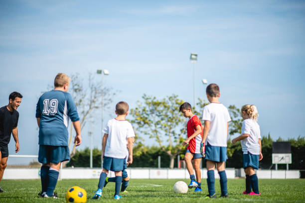 istock Mixed Age Range Footballers Practicing on Field with Coach 1322942679