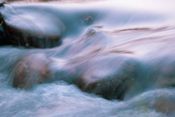 istock long time exposure of water flowing down some rocks. 1322944656