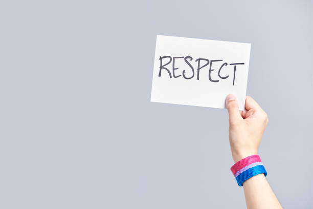 istock Hand with a bisexual flag bracelet holding a paper with a message: respect 1322947619