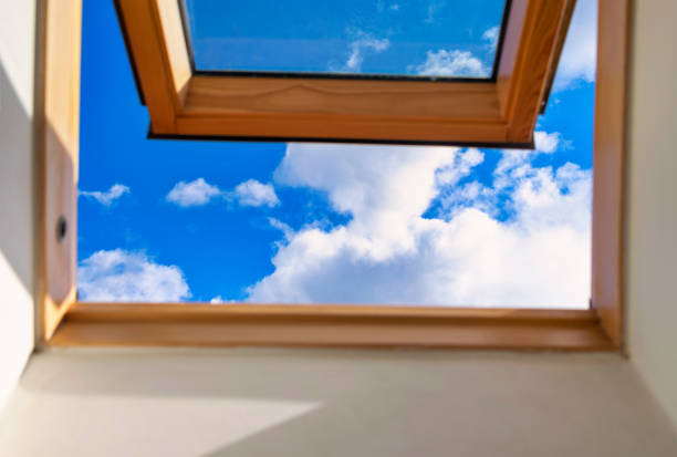 istock Looking up to the blue cloudy sky through modern square window. Selective blue sky 1322948329