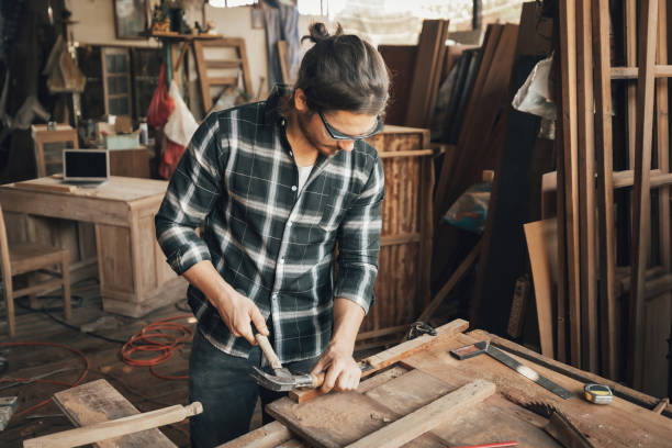 istock male carpenter using hammer and chisel on a piece of wood in workshop(vintage tone) 1322951362