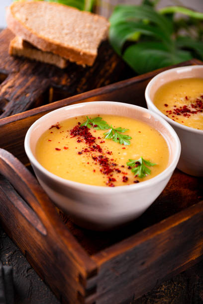 zwei schalen mit gespaltener erbsenpüreesuppe auf dunklem hintergrund aus nächster nähe vertikales foto - yellow split pea soup stock-fotos und bilder