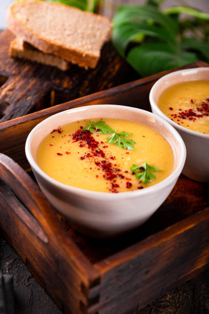 dos tazones de sopa de puré de guisantes partidos sobre fondo oscuro cerca de la foto vertical - yellow split pea soup fotografías e imágenes de stock