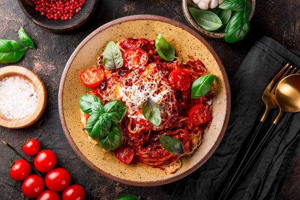 pasta italiana con salsa de tomate, tomates, queso y albahaca en una vista superior de fondo oscuro - salsa de tomate fotografías e imágenes de stock