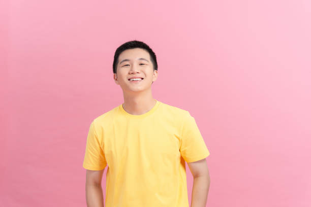istock A man with a yellow t-shirt standing looking at the camera 1322953182