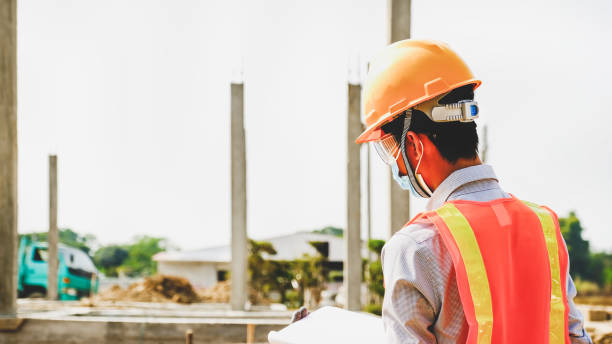 istock Engineer contractor man work safety industry project, check house plan design and investigating the size and quality in building construction structures site 1322956172