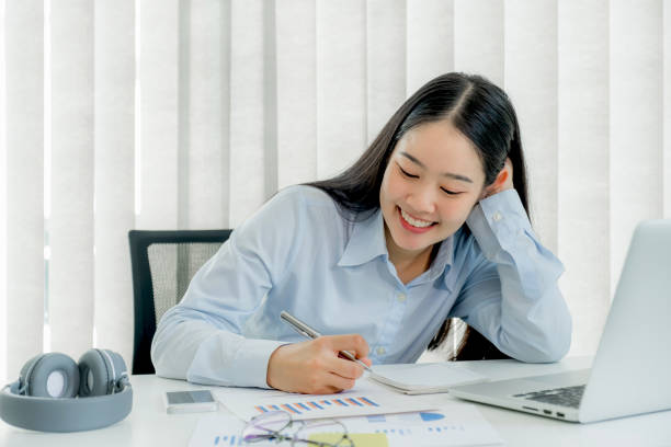 istock Young woman student taking notes watching laptop study online class video conference education elearning course from home 1322956266