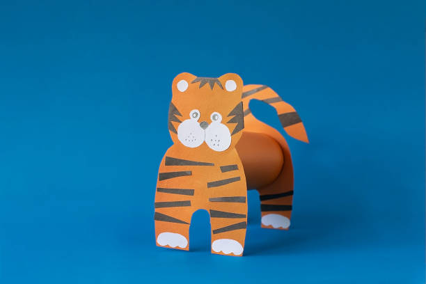 istock Step 6. Step by step instructions on how to make a tiger at home. Craft for New Year 2022. Take colored paper. A simple creative idea with your own hands. DIY children's art project 1322956470