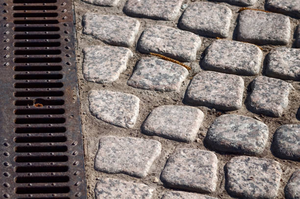 Street gray striped pavement and metal drainage system.