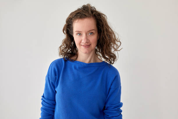 istock Smiling woman in blue knitted sweater white background 1322961322