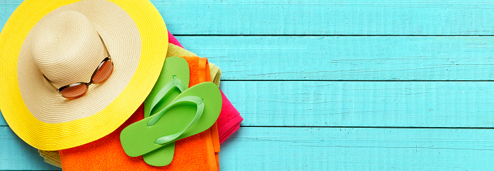 A colorful straw hat with pom poms on the brim. The hat is a bright and cheerful accessory that would be perfect for a sunny day or a festive occasion