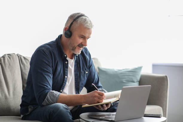 istock Positive mature man attending webinar from home 1322963615