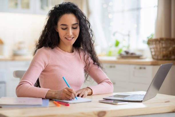istock Distance Education. Young Brunette Lady Study With Laptop At table In Kitchen 1322963815